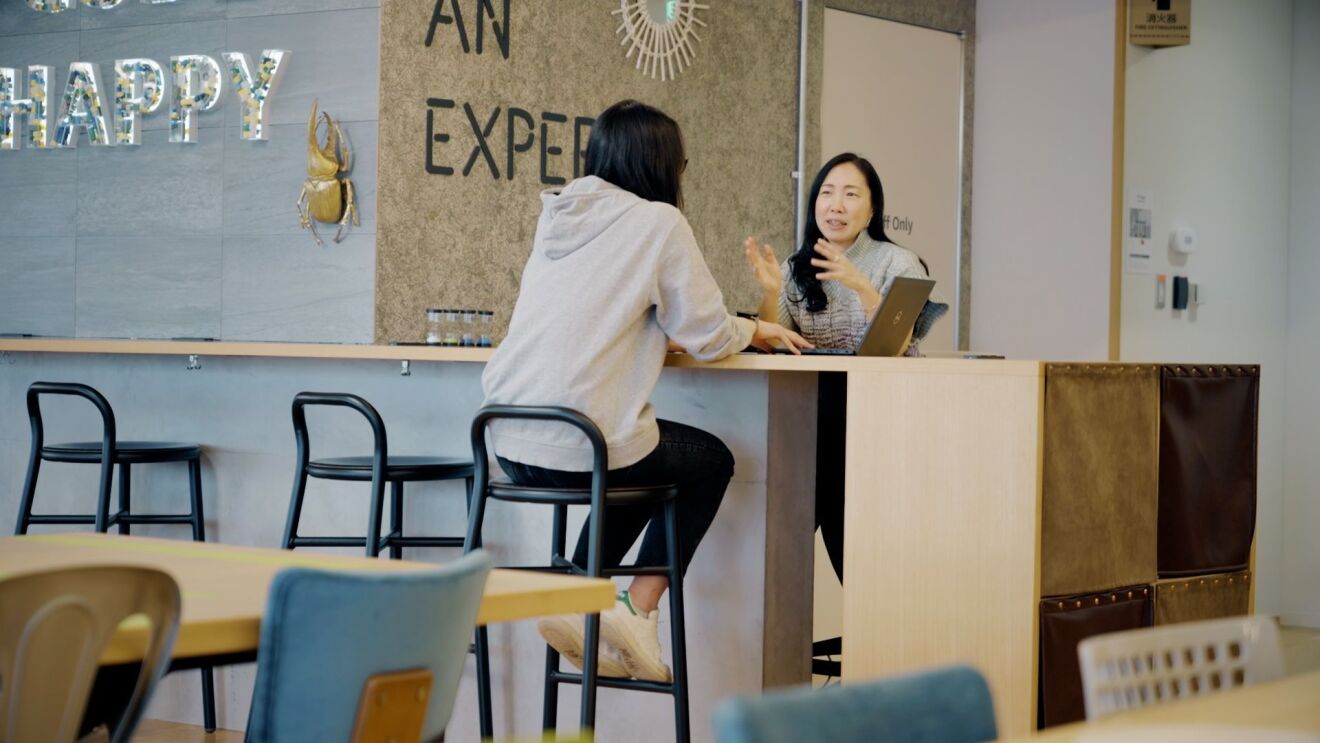 2人の女性がカウンターで座りながら話し合っている