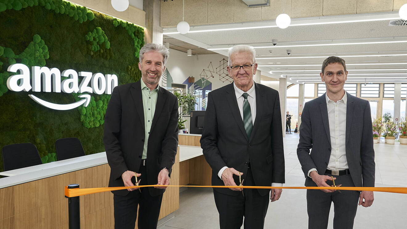 Während der Eröffnungsfeier des neuen Amazon Standorts in Tübingen zerschneiden Boris Palmer, Winfried Kretschmann und Michael Hirsch ein Band.