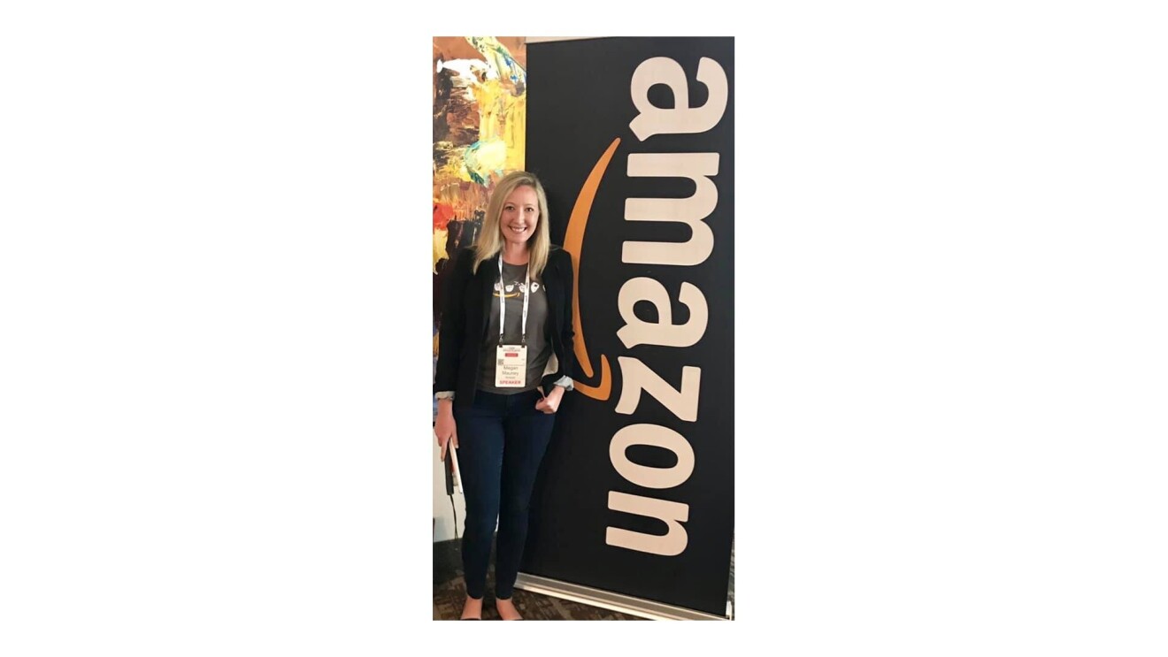 Megan standing next to a sign that says, “Amazon”.