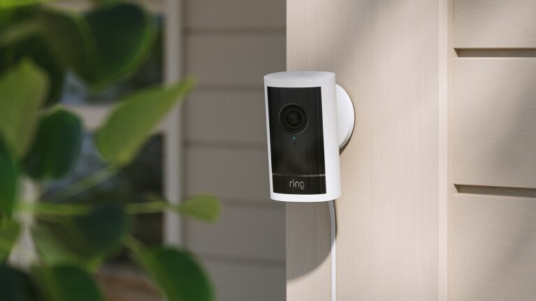 Ring video doorbell mounted on exterior wall near greenery
