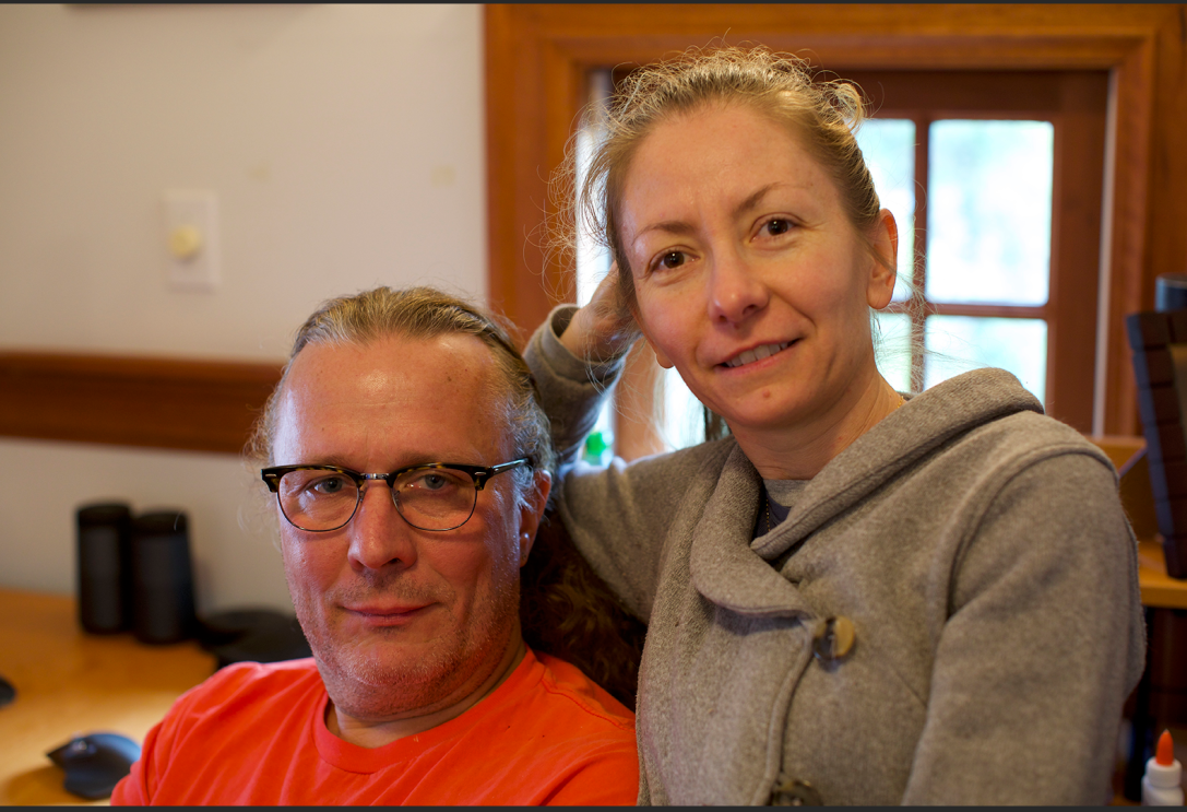 An image of a man and woman smiling for a photo in their home.