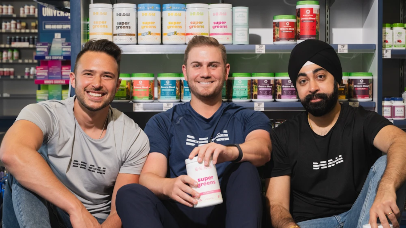 Be Amazing co-founders Mike Yewdell, Russell Saks, and Tarun Singh standing in front of shelves stocked with their nutritional supplement products