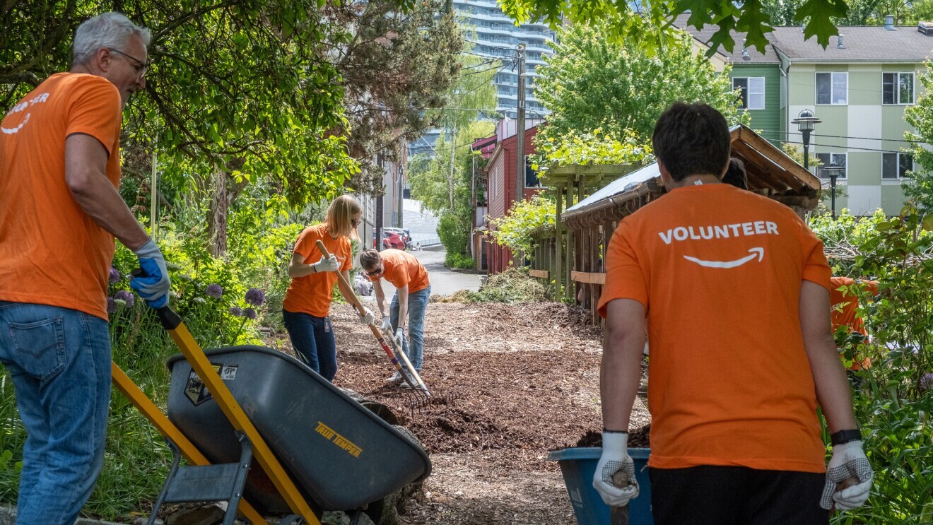 Amazon employees volunteering in a park cleanup project.