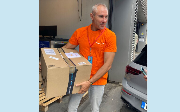 An image of Stefano Perego working with employees at an amazon facility.