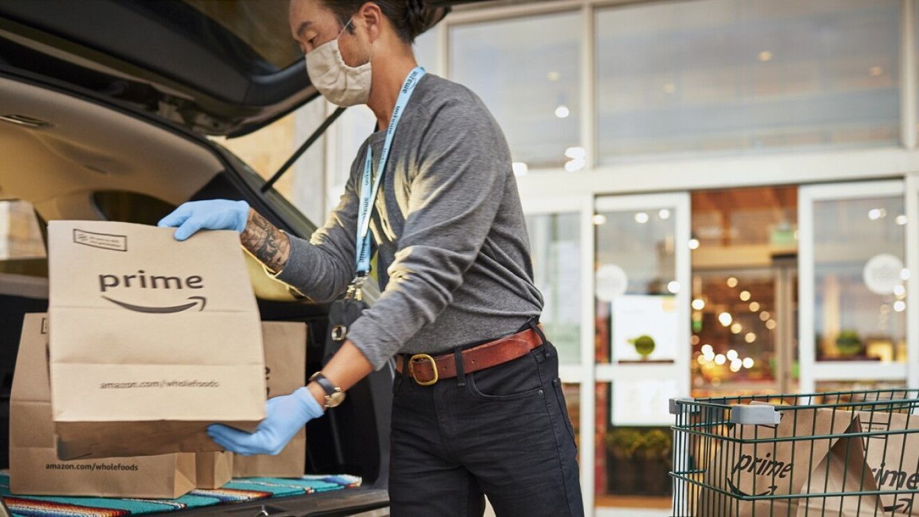 Whole Foods Market location with Team Member safely handling customer groceries