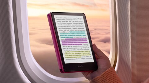 Une main tenant un Kindle Colorsoft pour lire dans l'avion