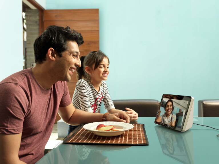 A man and a little girl (maybe father and daughter), speak to a lady (maybe the girl's mother), on an Echo show device