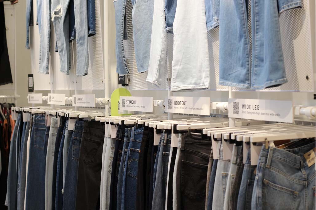 An image of a wall of jeans at the Amazon Style store. The jeans are sectioned off with labels that read "straight," "bootcut," and "wide leg."