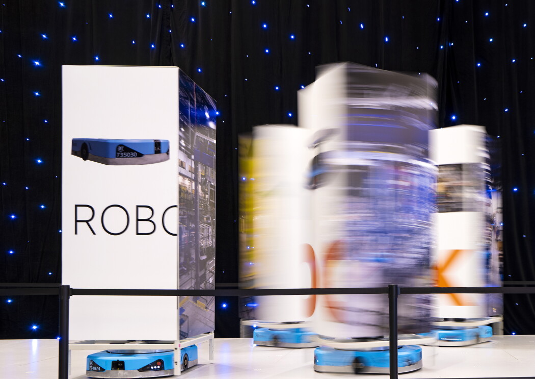 An image of small floor robots moving around a showcase on the showroom floor at re:MARS.