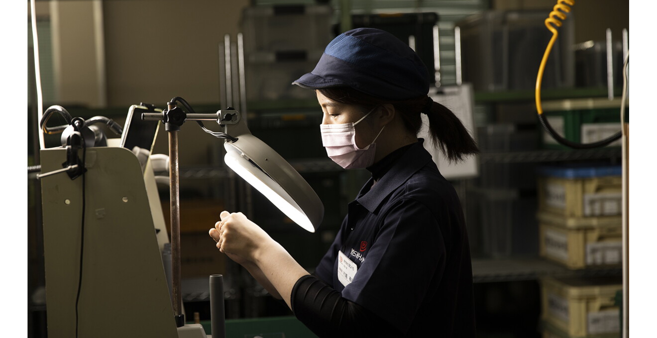 作業服を着たスタッフがひとつひとつ検品している写真