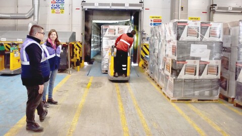 Amazon employees load donations into a truck via a forklift.