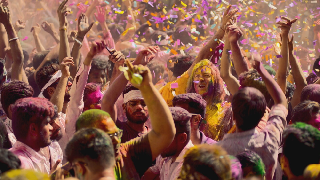 James May celebrates in a crowd in India covered in colourful paint