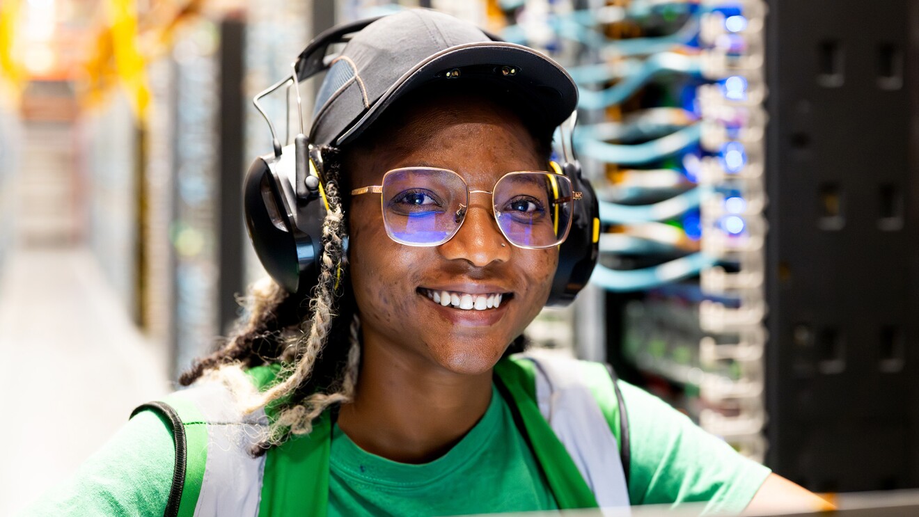A data center technician smiling