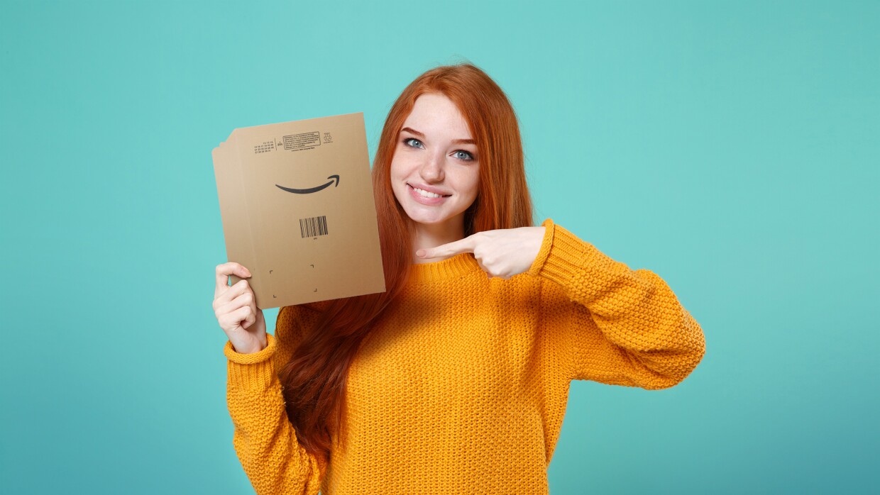 Une jeune femme tient un sac en papier recyclable Amazon dans sa main