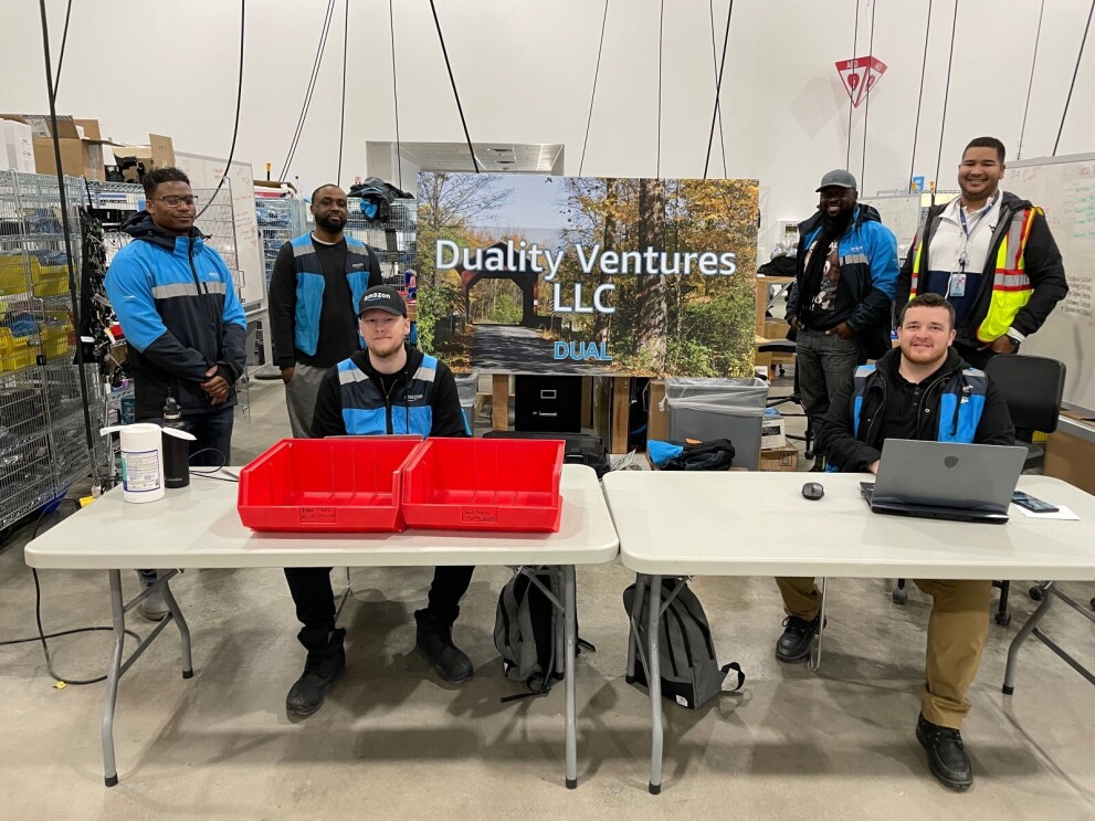 The Duality Ventures team poses for a picture wearing their Amazon uniforms.