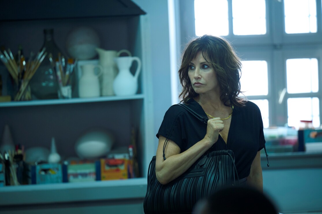 Dark-haired woman in casual attire in moody kitchen scene