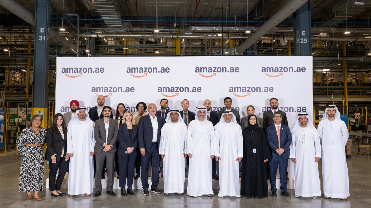 Image of people standing in front of an Amazon.ae branded rollup