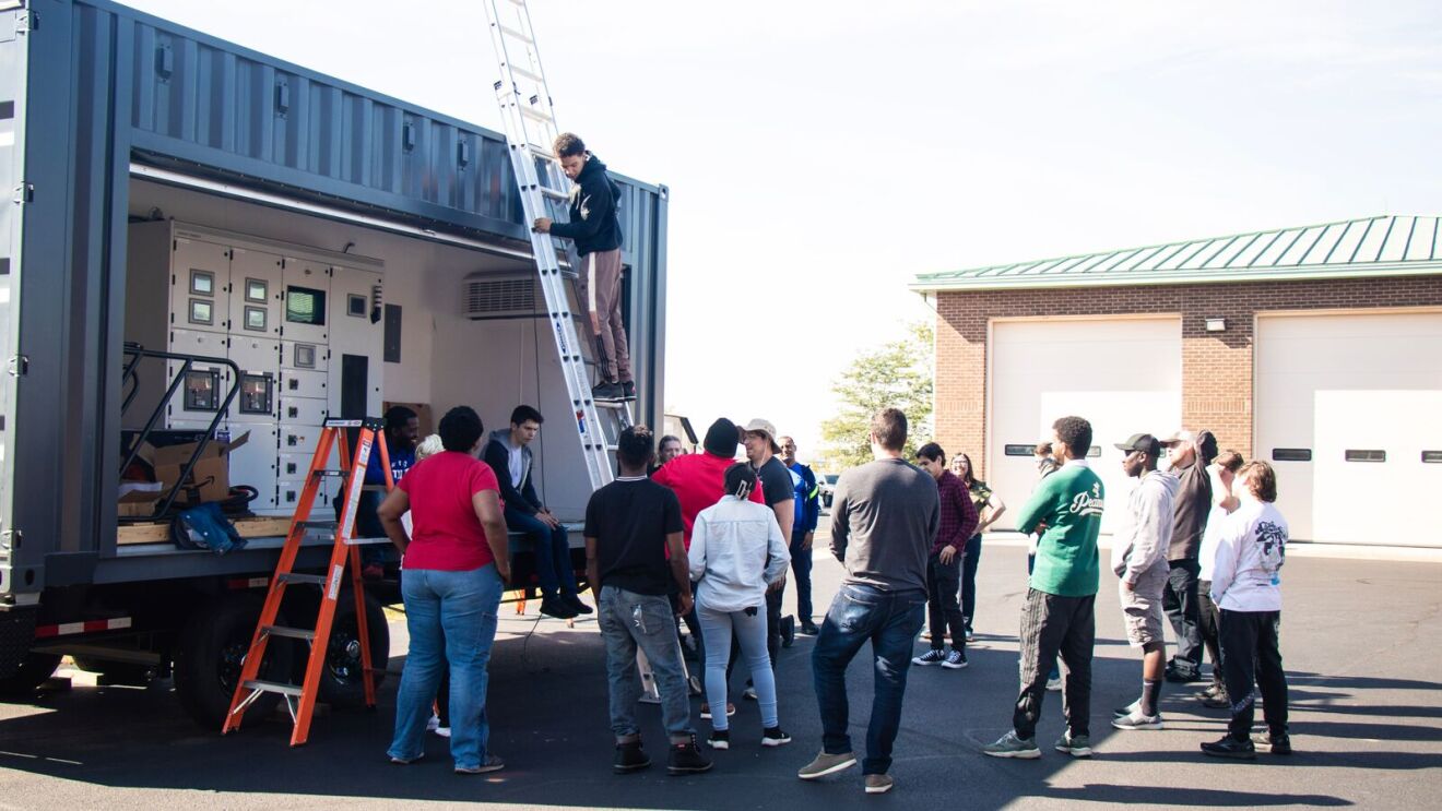 AWS training in Columbus OH: students outside surrounding someone on a ladder
