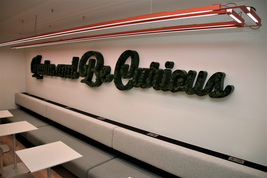 Sign at the Amazon Manchester offices reading "Learn and Be Curious"