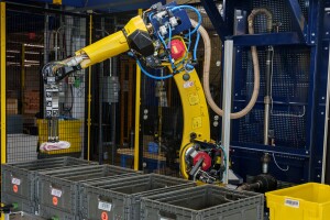 A robotic arm moves products from a bin in an Amazon fulfillment center.