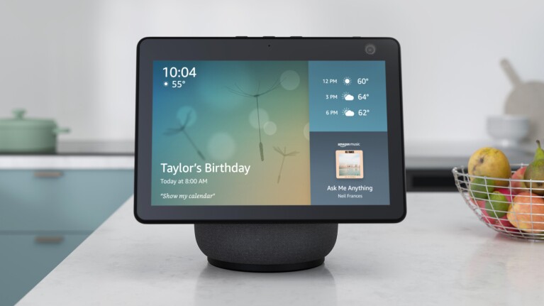 An image of an Amazon Echo Show device showing the homescreen, including the weather, a calendar update that ways "Taylor's Birthday," and "Ask Me Anything" by Neil Frances playing on Amazon Music.