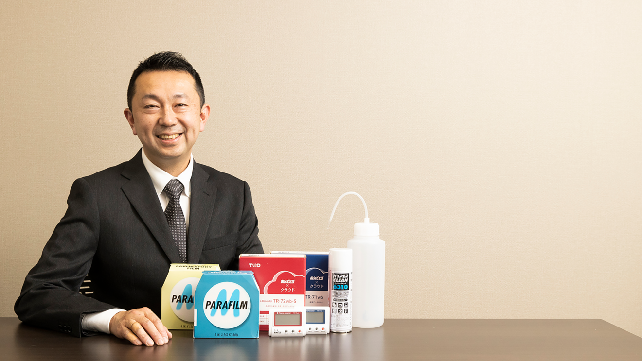 取り扱う商品の横で、笑顔の内山さんの写真