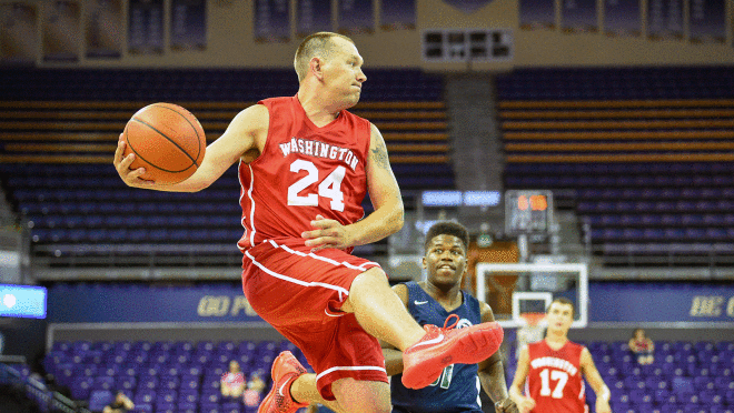 篮球运动员的形象与球跳他们的手在2022年特殊奥运会。还有其他球员对他们在后台运行。