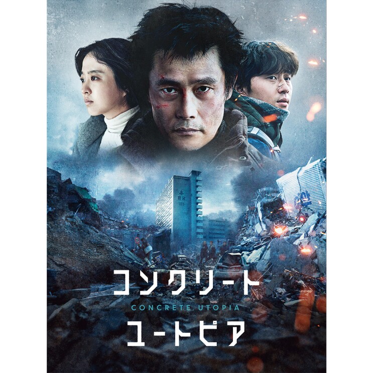 顔に傷がある男性の後ろにショートカットの女性と救護隊のユニフォームを着た男性。その下には破壊され、煙が立ち上っている街