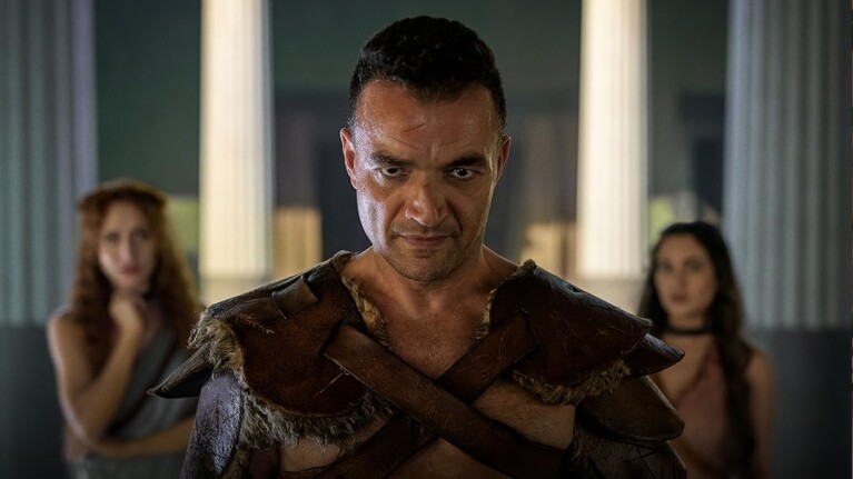 Nick E. Tarabay in Spartacus: House Of Ashurwith two women in the background.