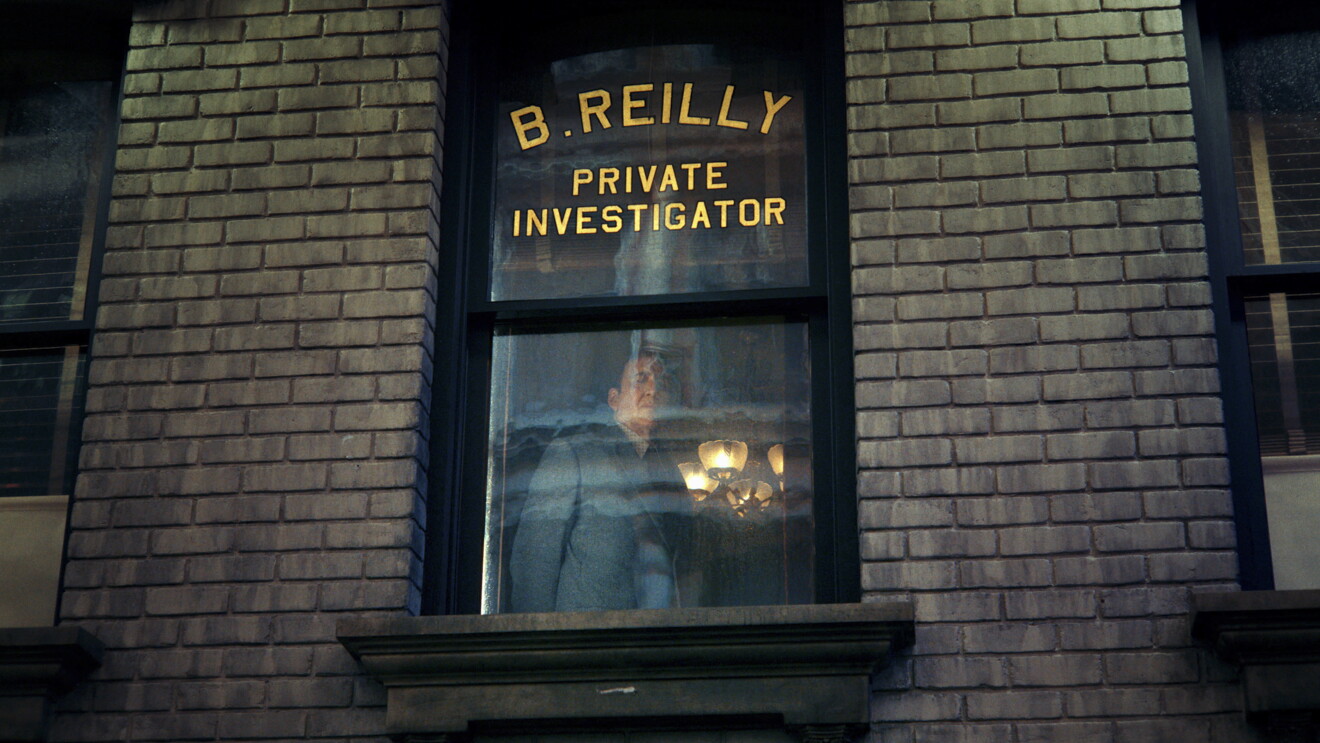 Private investigator's office window with glowing light inside, Nicolas Cage as Bill Reilly.
