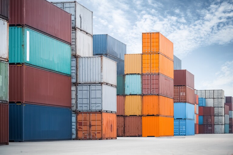 Multi-color shipping containers stacked in a freight yard