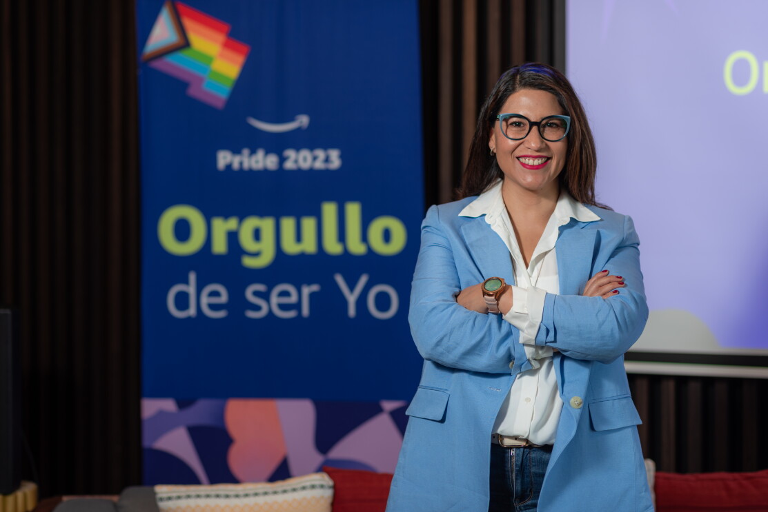 Erika Toscano posando para una foto con los carteles de la campaña Orgullo de ser yo. 