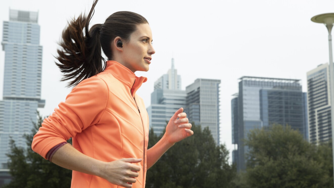 A woman running on a street wearing Echo Buds
