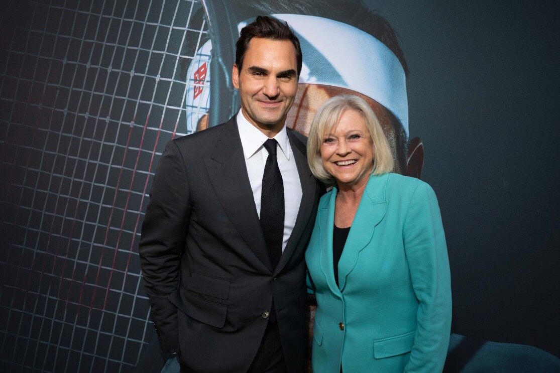 Tennis stars Roger Federer and Sue Barker holding each other and smiling