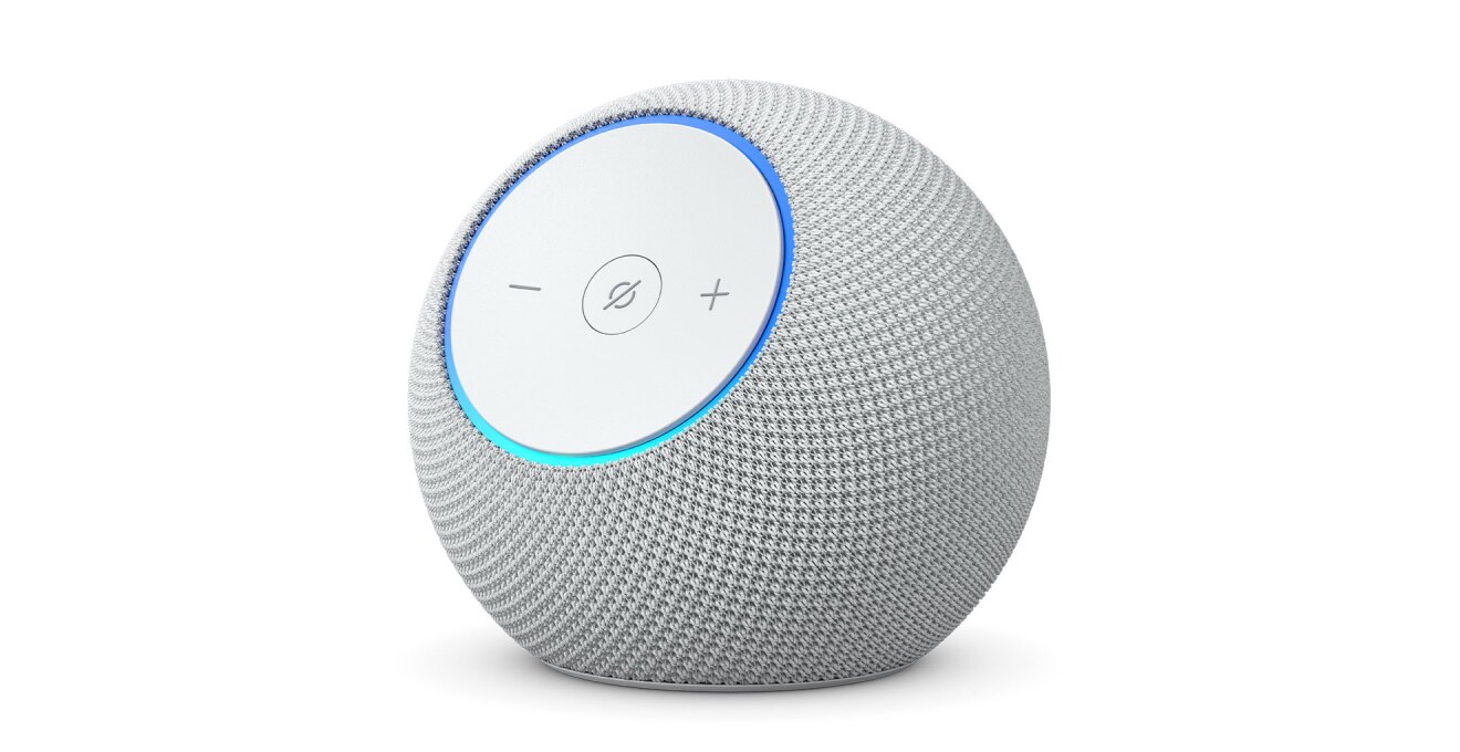 白背景に、白い球形のデバイス。前面の丸いパネルに「-」「+」ボタンと、中央に斜線入りの丸アイコン。パネルの外周部分が青く点灯している。パネル以外の本体表面はメッシュ状。