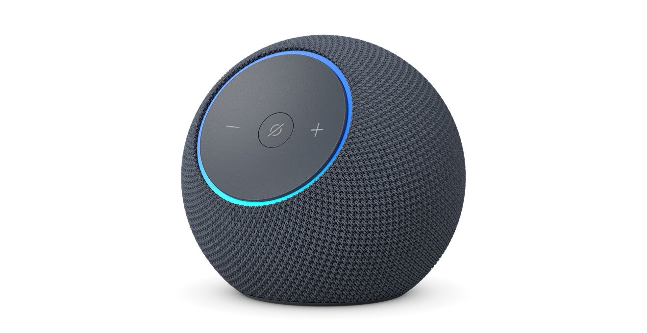 白背景に、黒い球形のデバイス。前面の丸いパネルに「-」「+」ボタンと、中央に斜線入りの丸アイコン。パネルの外周部分が青く点灯している。パネル以外の本体表面はメッシュ状。