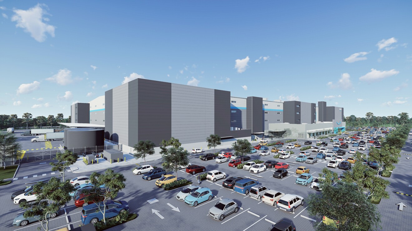 Large Amazon fulfillment center with expansive parking lot full of vehicles