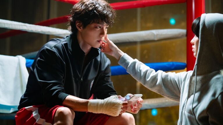 Boxer receiving comforting touch from woman in hood