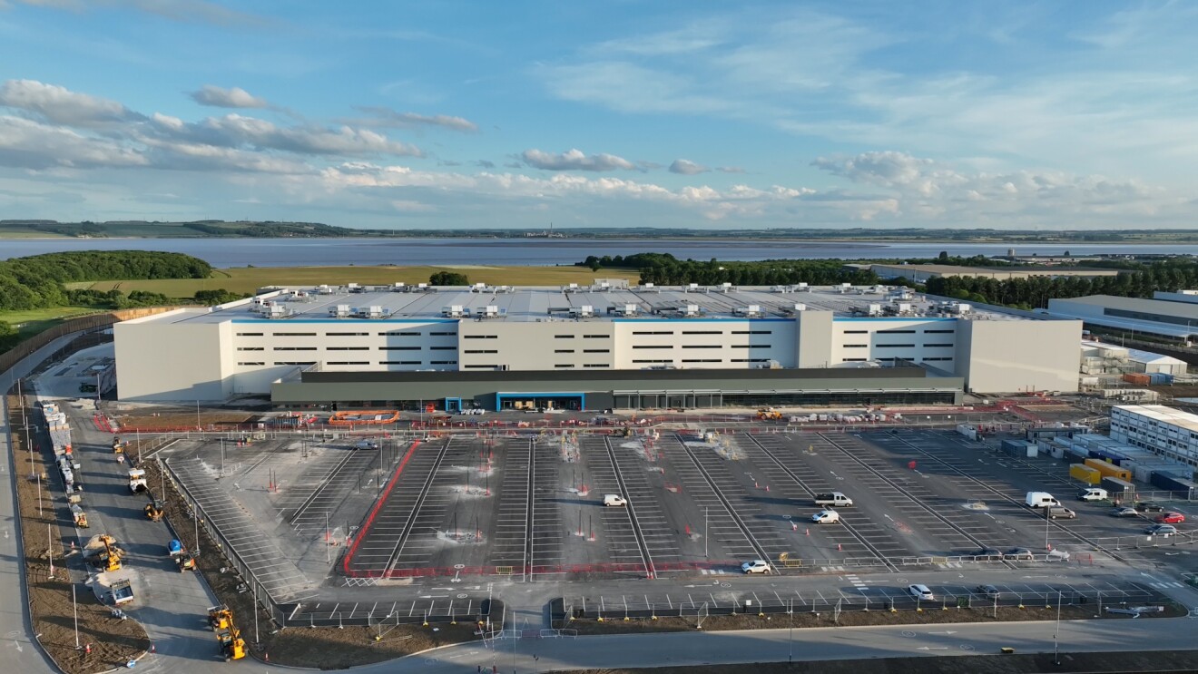 Large-scale Amazon fulfilment centre surrounded by waterfront scenery