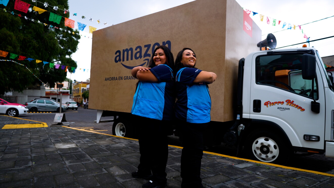Michelle Rodríguez, y Marimar Terrón delante del camión que simula una caja de Amazon. 