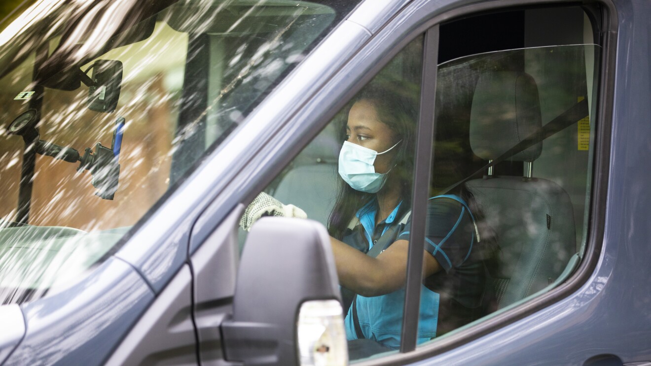 A woman driving an Amazon delivery vehicle