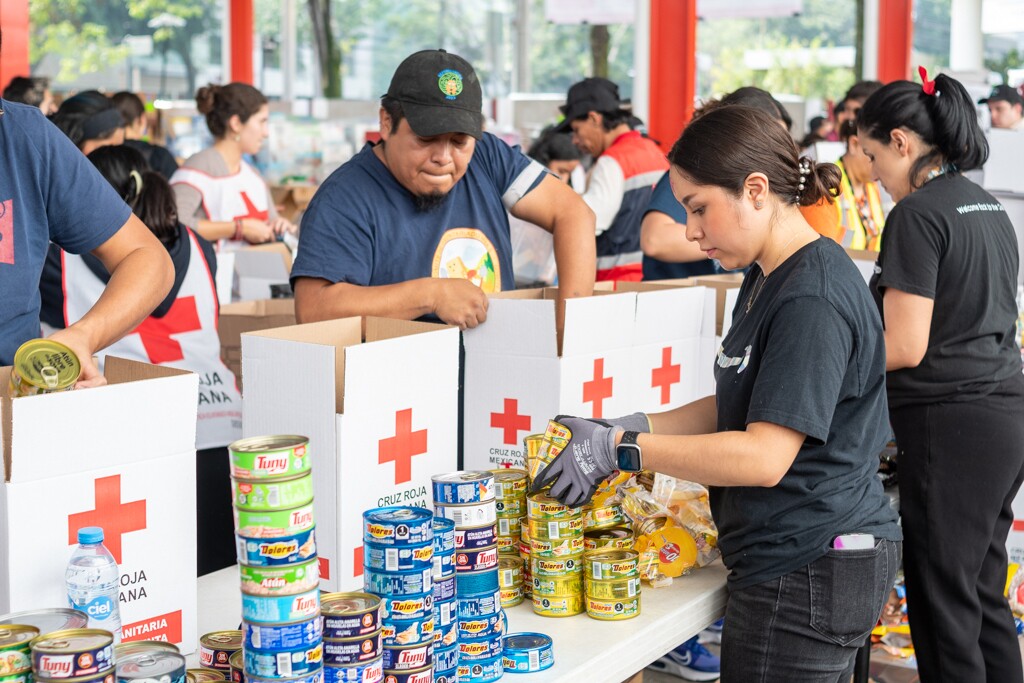 Voluntarios de Amazon encajando productos en cajas de la Cruz Roja.