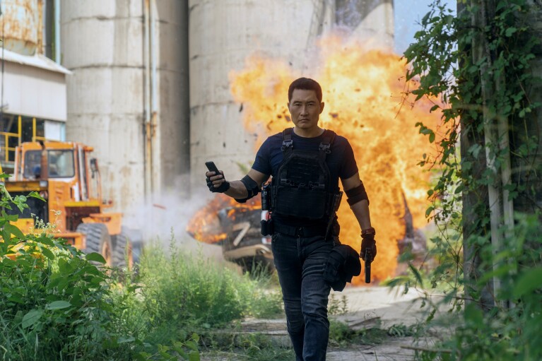 Man in tactical gear walking away from explosion