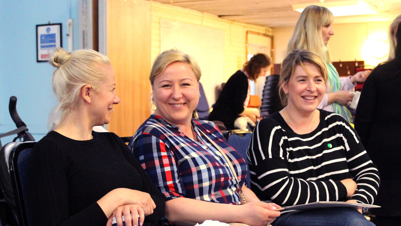 In Kind Direct charity photograph of three people sitting next to each other smiling 