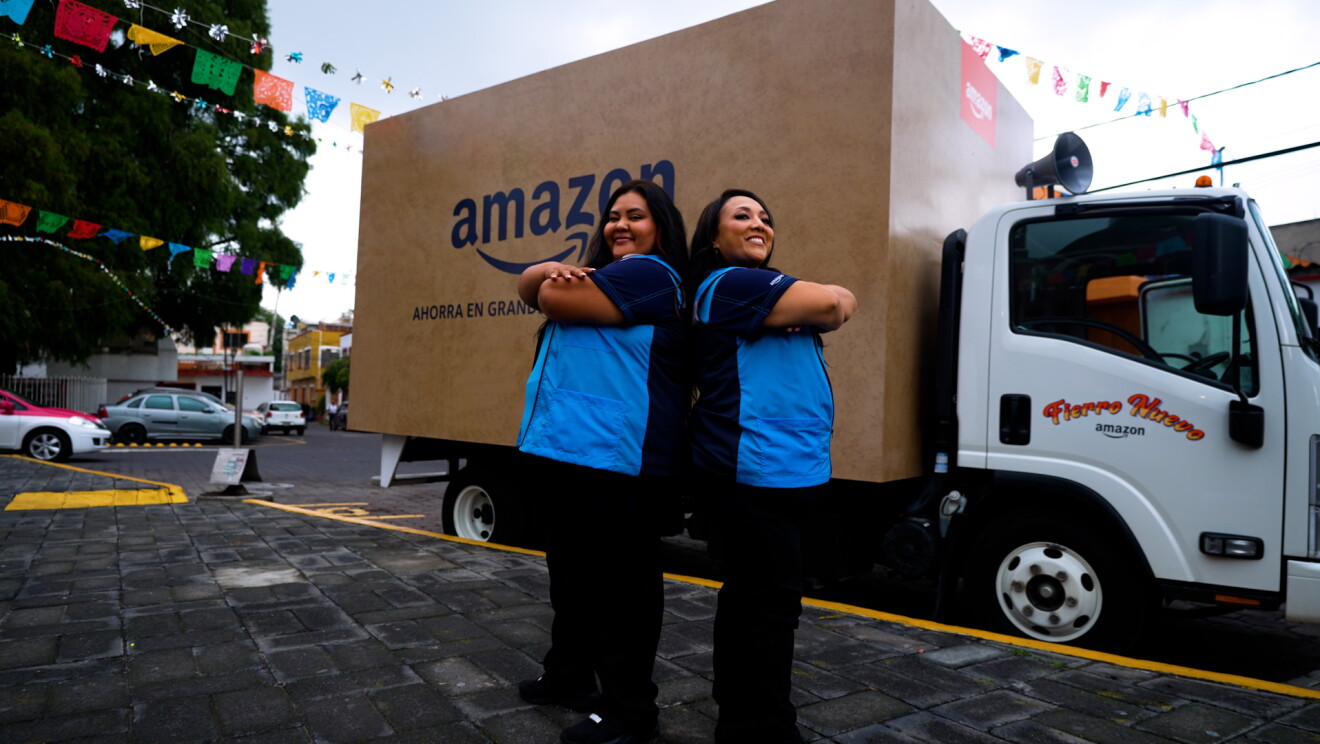 Michelle Rodríguez, y Marimar Terrón delante del camión que simula una caja de Amazon. 
