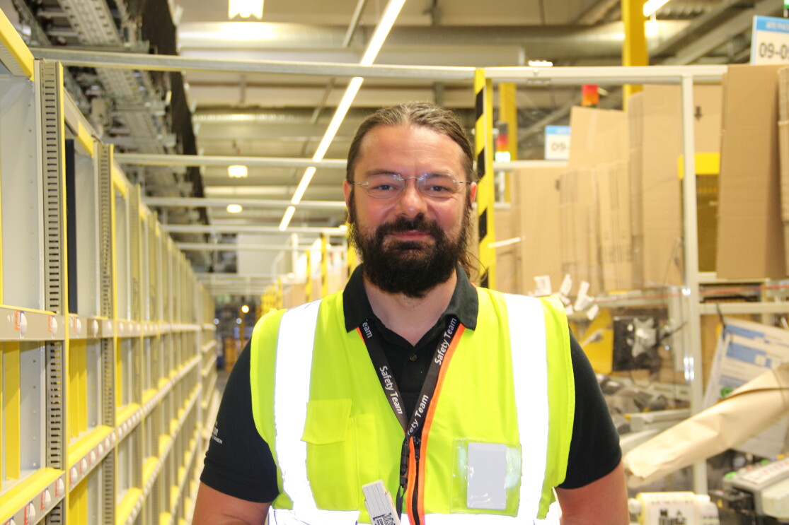Amazon-Arbeitssicherheitsexperte Lucian Geiger mit gelber Weste im Logistikzentrum.