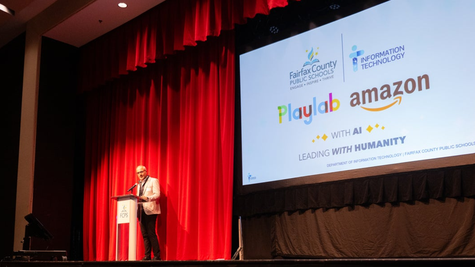 Presenter on stage with Fairfax County Schools and Amazon AI partnership slide