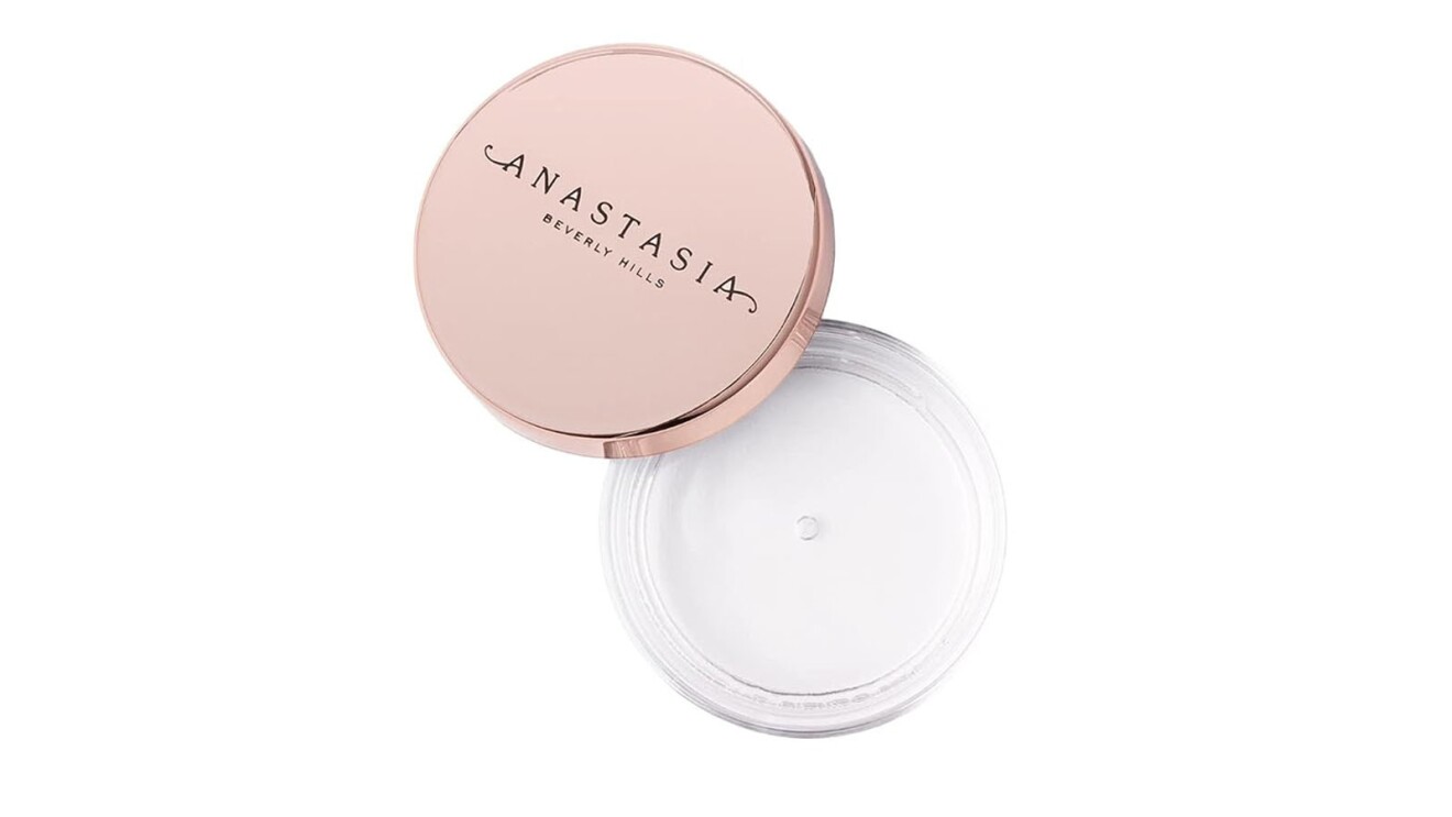 An image of the Anastasia Beverly Hills Brow Freeze product. It's a small, circular container with a rose gold lid and a clear container with a clear gel inside.