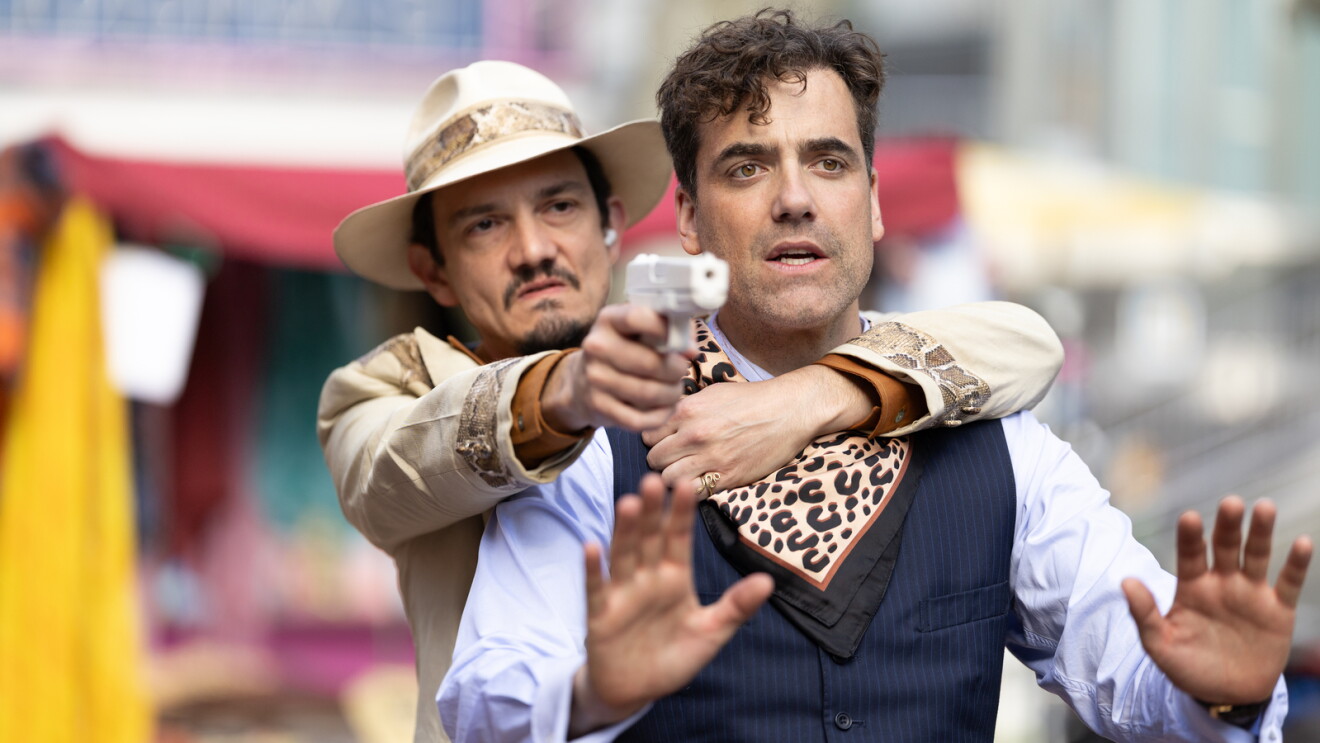 Sebastian Armesto as The Cuban holds Daniel Ings as Sam Unai Mateo at gunpoint
