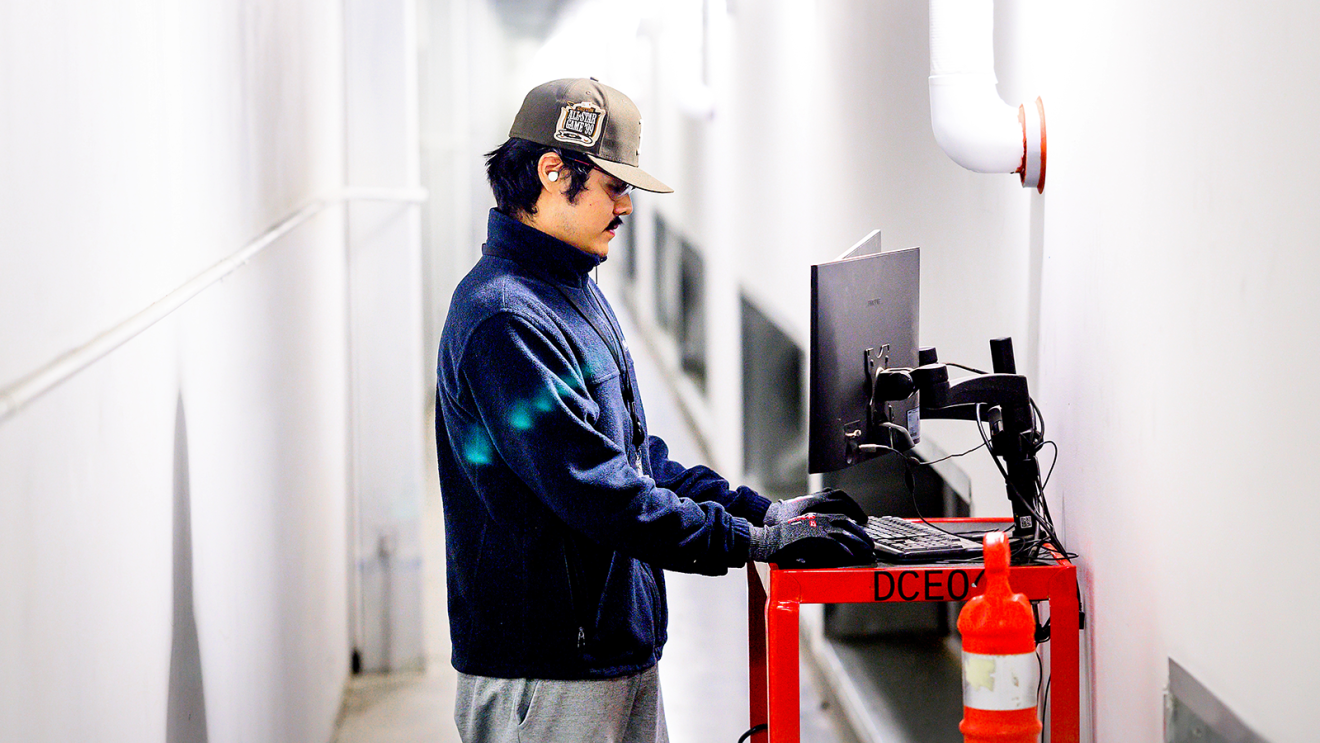 A technician working on a computer inside a data center.